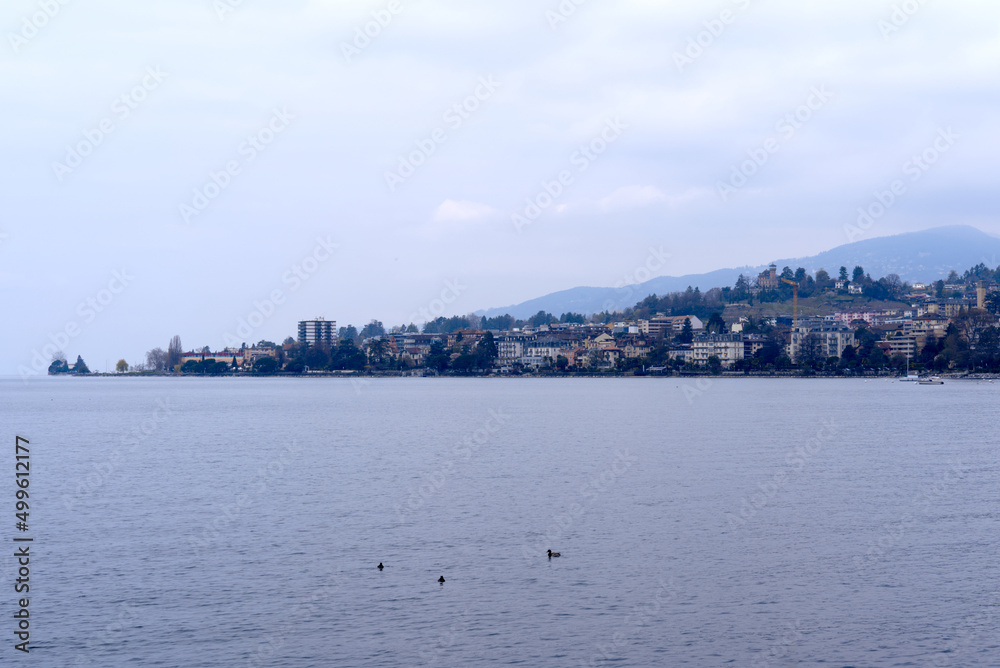Lakeshore with riviera and skyline at City of Montreux with Lake Geneva on a cloudy spring day. Photo taken April 4th, 2022, Montreux, Switzerland. Lakeshore with riviera and skyline at City of Montreux with Lake Geneva on a cloudy spring day. Photo taken April 4th, 2022, Montreux, Switzerland.