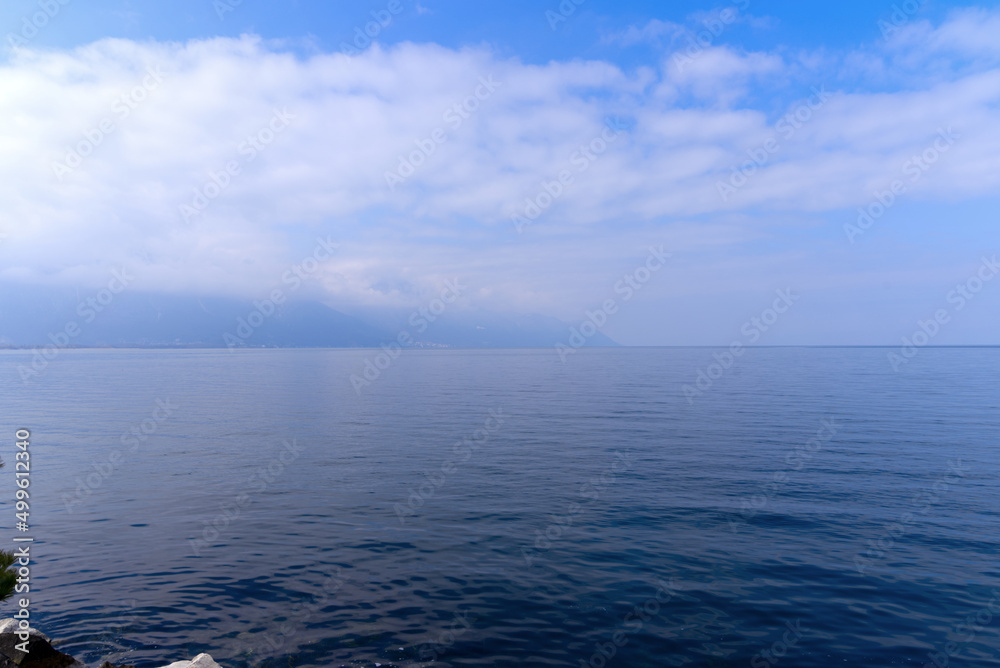 Lakeshore with riviera and skyline at City of Montreux with Lake Geneva on a cloudy spring day. Photo taken April 4th, 2022, Montreux, Switzerland. Lakeshore with riviera and skyline at City of Montreux with Lake Geneva on a cloudy spring day. Photo taken April 4th, 2022, Montreux, Switzerland.