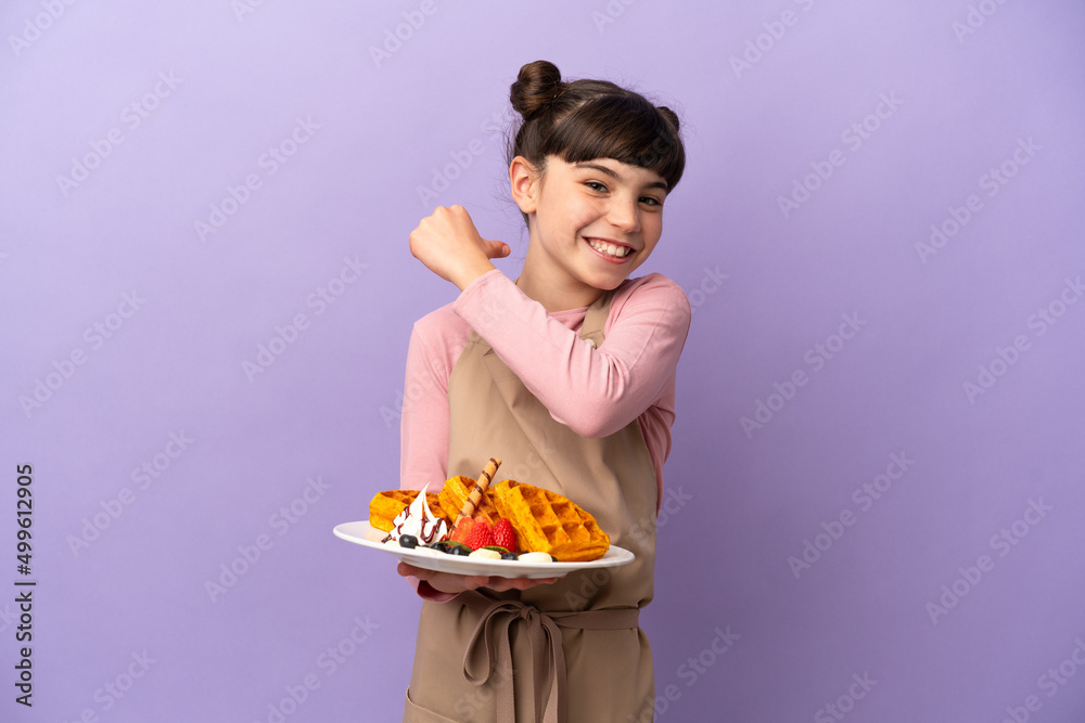 Little caucasian girl holding waffles isolated on purple background proud and self-satisfied Little caucasian girl holding waffles isolated on purple background proud and self-satisfied