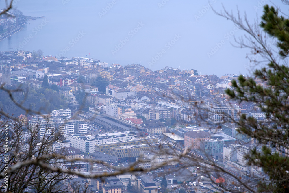 Aerial view over City of Vevey with Lake Geneva in the background on a cloudy spring day seen from Funicular Vevey-Mont-Pèlerin. Photo taken April 4th, 2022, Vevey, Switzerland.
