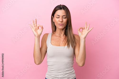 Middle age caucasian woman isolated on pink background in zen pose