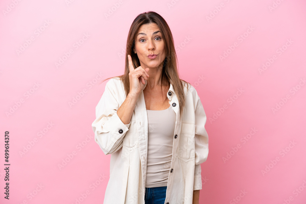 Middle age caucasian woman isolated on pink background intending to realizes the solution while lifting a finger up Middle age caucasian woman isolated on pink background intending to realizes the solution while lifting a finger up