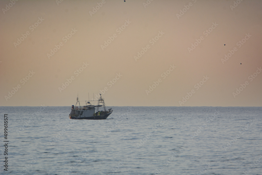 Nice little fishing boat on the Mediterranean sea at sunset