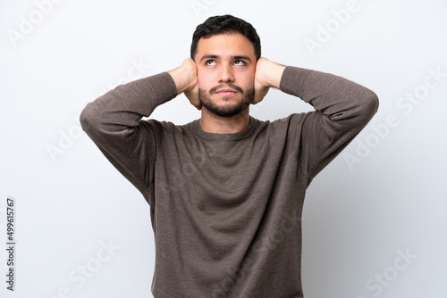 Young Brazilian man isolated on white background frustrated and covering ears © luismolinero