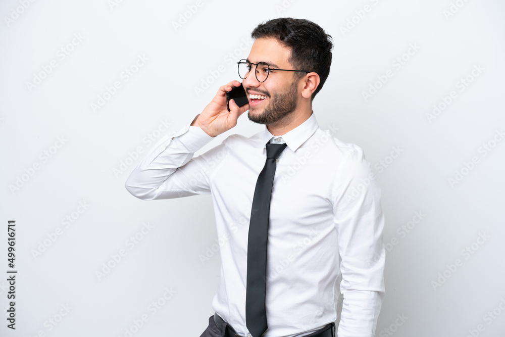 Business Brazilian man isolated on white background keeping a conversation with the mobile phone Business Brazilian man isolated on white background keeping a conversation with the mobile phone