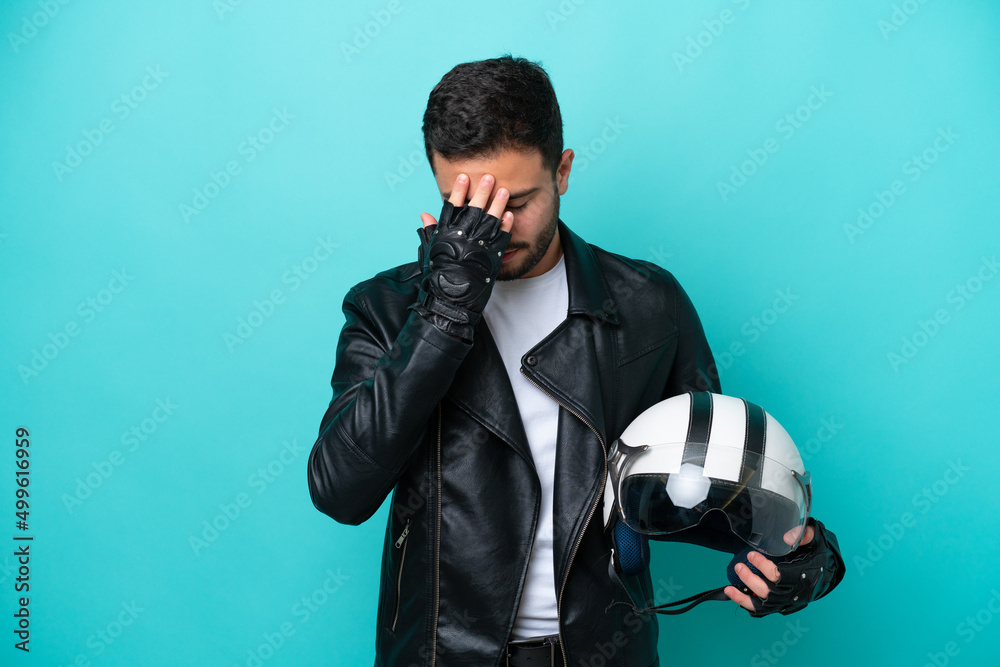 Young Brazilian woman with a motorcycle helmet isolated on blue background with tired and sick expression Young Brazilian woman with a motorcycle helmet isolated on blue background with tired and sick expression