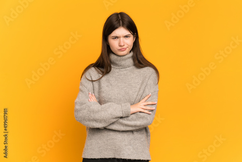 Young Ukrainian girl isolated on yellow background feeling upset © luismolinero
