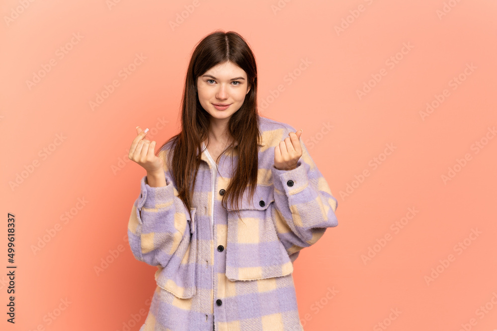 Young Ukrainian girl isolated on pink background making money gesture but is ruined Young Ukrainian girl isolated on pink background making money gesture but is ruined