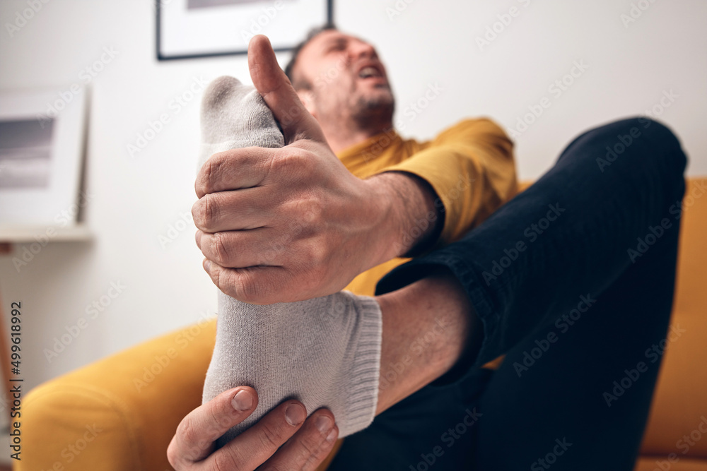 Adult male with foot pain, dislocation, numbness, cramp and other joint issues. Stock Photo
