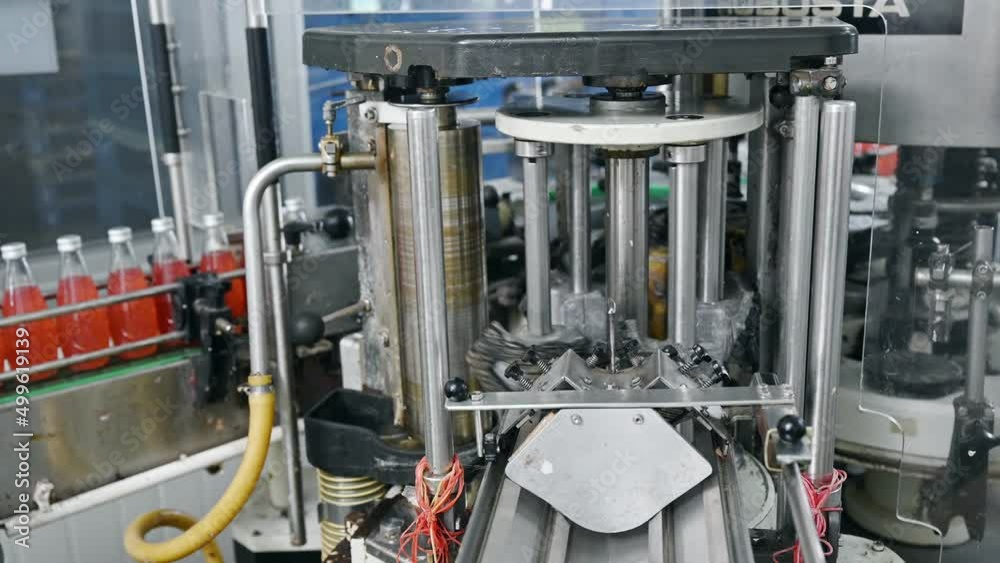 Automatic product labeling machinery working with red juice in production line at bottling factory machinery Automatic product labeling machinery working with red juice in production line at bottling factory machinery