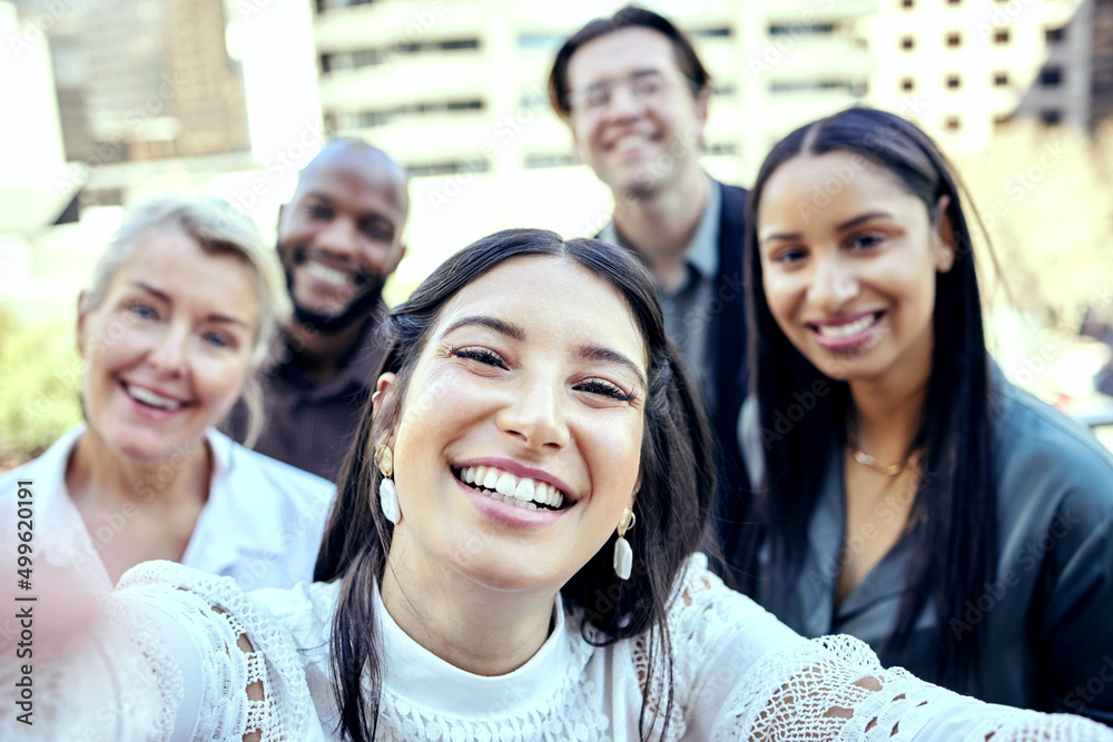 Obraz premium I find the harder we work, the more we have. Shot of a group of business colleagues taking selfies outside.