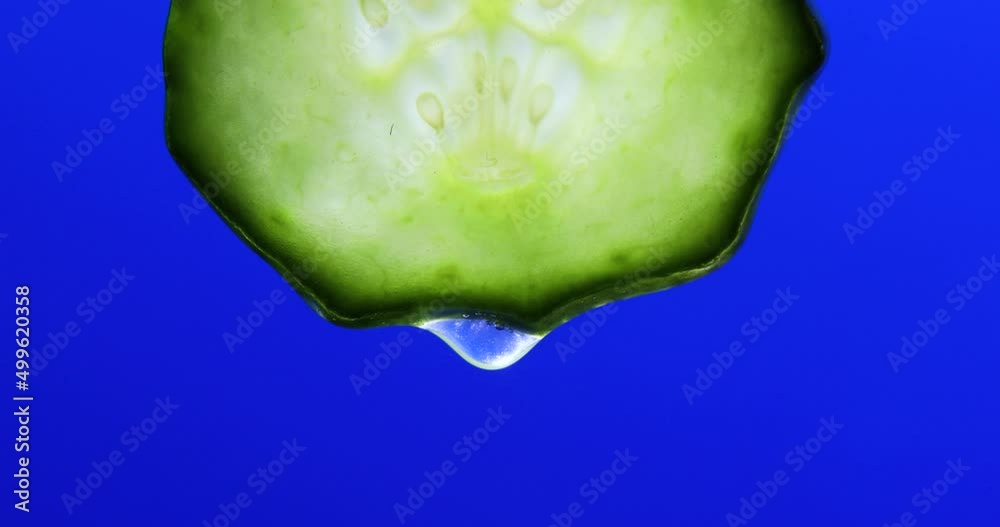Gel, juice drips from cucumber slices with gel on blue background, natural medicinal plant for organic cosmetics, alternative medicine, health and beauty spa concept, drop of cucumber.