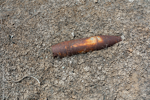 Valokuvatapetti Rusty military bomb shell in the ground