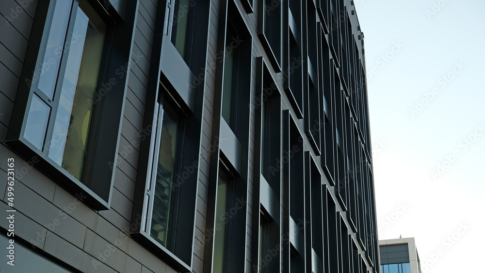 Exterior of modern dark house object. Architectural detail of a skyscraper, close-up on the windows. Real estate, residential apartments and offices. Living apartments or office building architecture.