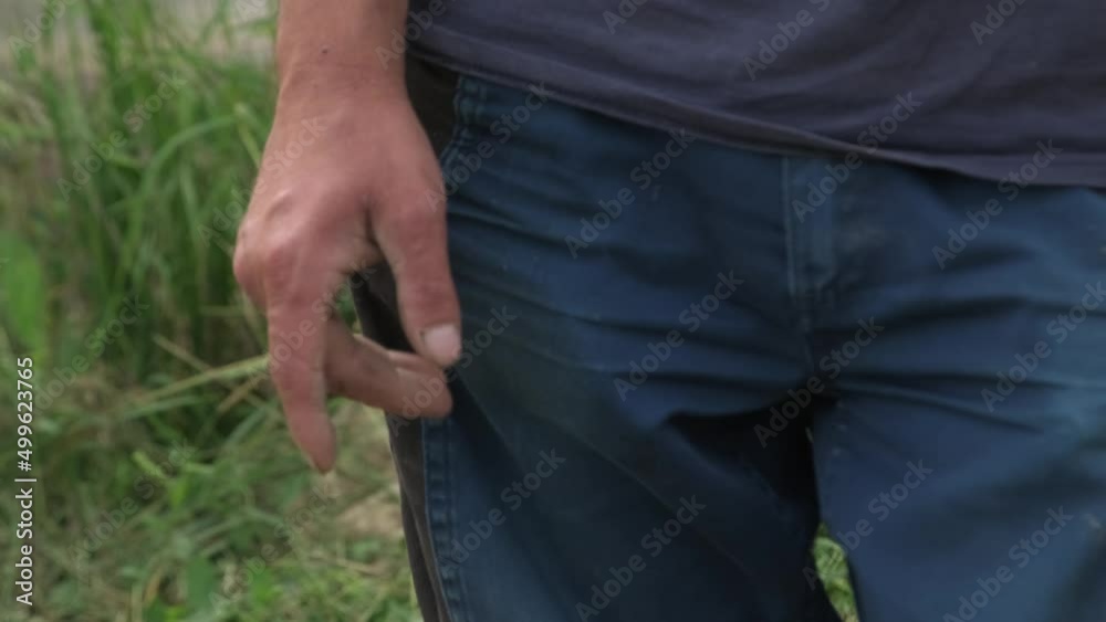 Closeup Of Hands And Pants Of An Agricultural Farmer During Harvest Season Closeup Of Hands And Pants Of An Agricultural Farmer During Harvest Season