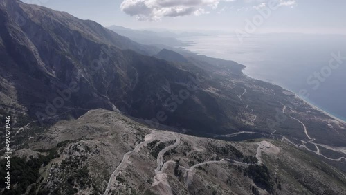 drone video over the Llogara mountain pass on SH8, Albania. Front shot from a bird's eye view advancing on the road with the horizon in the sea in two turquoise colors and the mountain. photo