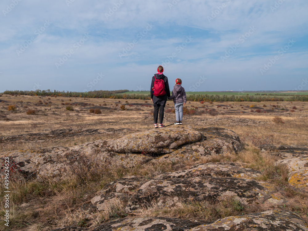 Travelers mother daughter raising hands on mountain summit spending time together walking climbing enjoying scenic landscape cloudy sky.Active lifestyle candid family having fun Parenthood Mothers day