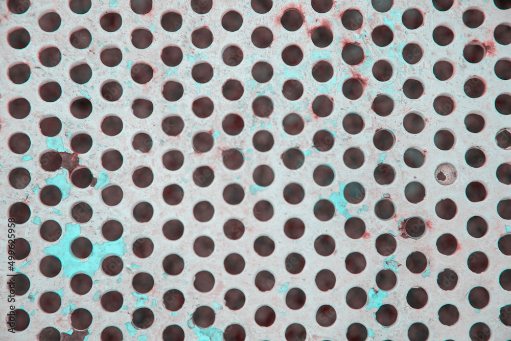Photography of a metallic surface in the shape of a geometric grid.