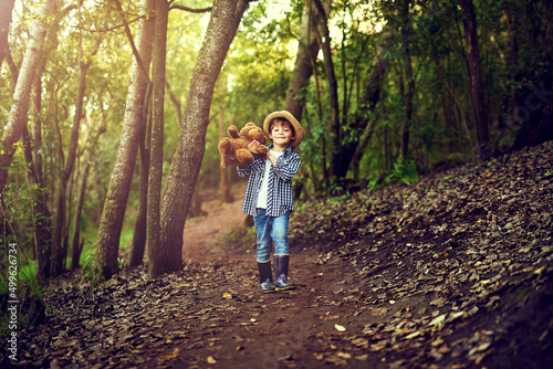 Teddy and I are quite excited about this adventure. Shot of a little boy sitting in the forest with his teddy bear.