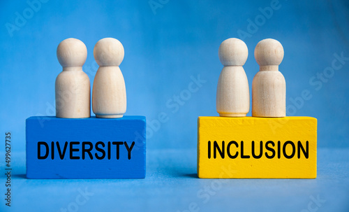 Diversity and inclusion text on wooden blocks with wooden dolls. Togetherness concept