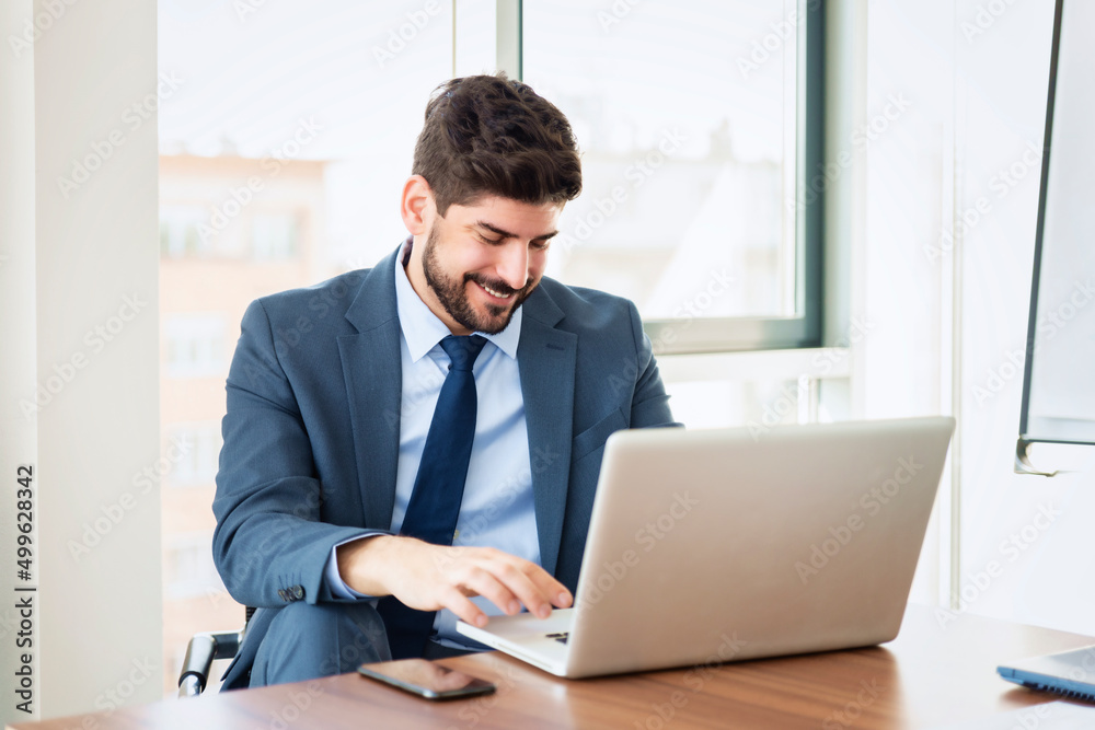 Businessman working on laptop in a modern office Businessman working on laptop in a modern office