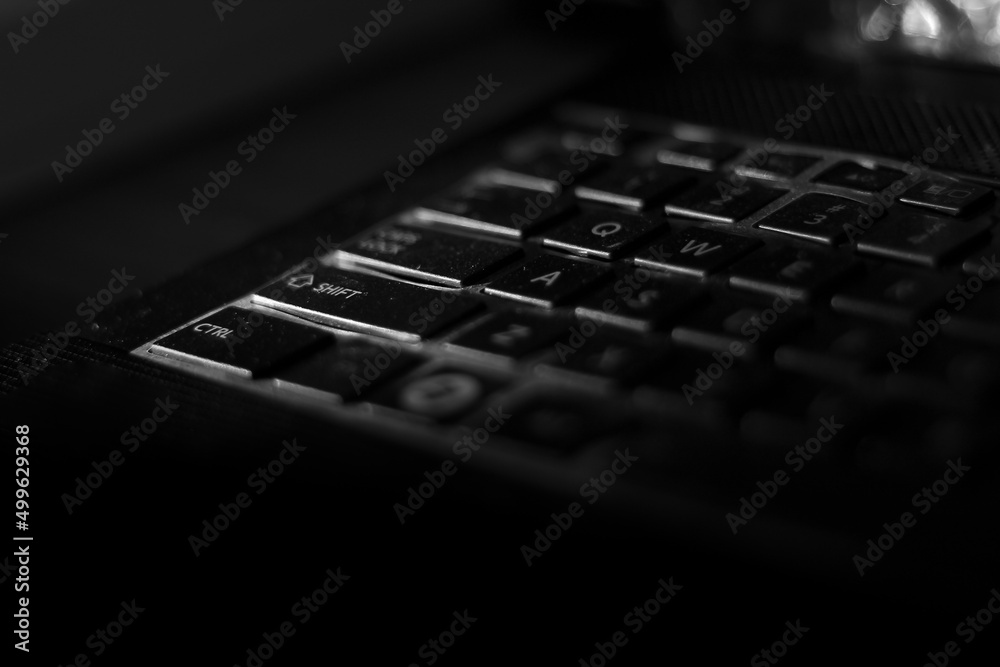 low light of laptop keyboard with dark background. black and white photography. copy space for computer accessories, computer spare parts and laptop hardware.