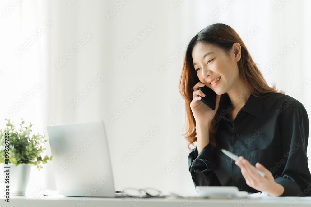 Asian businesswoman in formal suit in office happy and cheerful during using smartphone and working Asian businesswoman in formal suit in office happy and cheerful during using smartphone and working