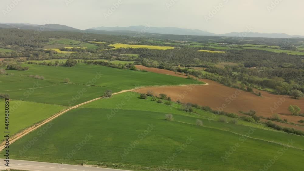 Aerial images of an impressive newly cultivated green field on the Costa Brava in Girona with the Pyrenees mountains in the background cycling tourism Aerial images of an impressive newly cultivated green field on the Costa Brava in Girona with the Pyrenees mountains in the background cycling tourism