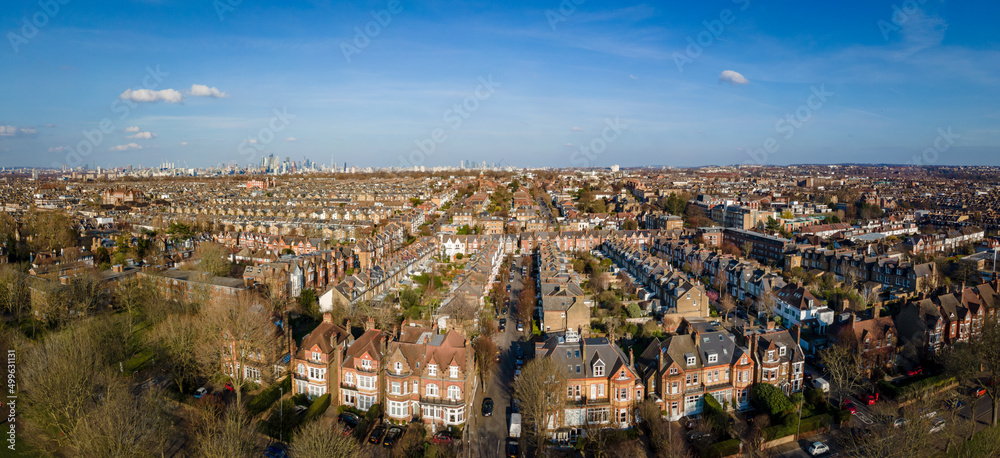 London- Panoramic aerial view of terraced house rooftops  in south west London with the City of London on the horizon 