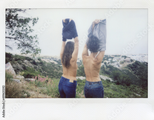 Girls taking off their shirts against landscape.