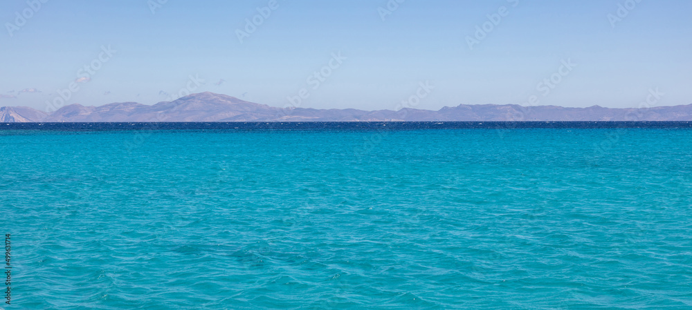 Koufonisia island, Cyclades, Greece. Panoramic view from Aegean ripple sea of rocky landscape. Banner