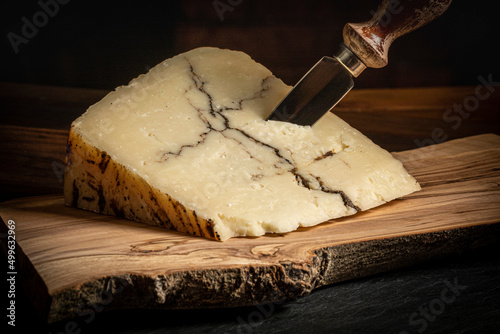 Italian Sheep Milk Cheese with Black Truffle Veining on a Wood Board