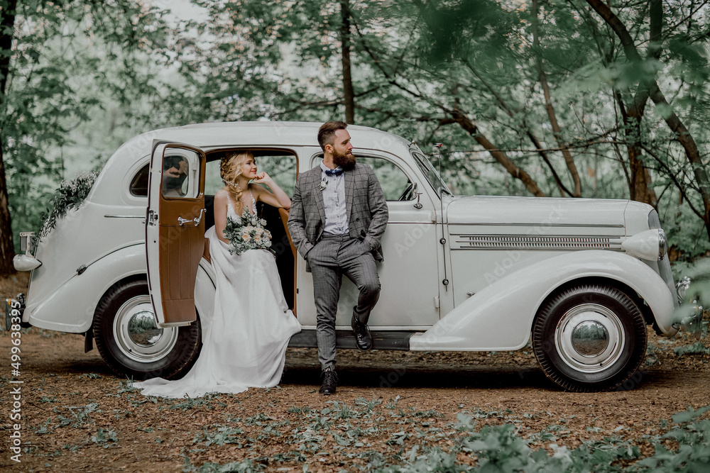 The bearded groom and beautiful bride. Retro car. The bearded groom and beautiful bride. Retro car.
