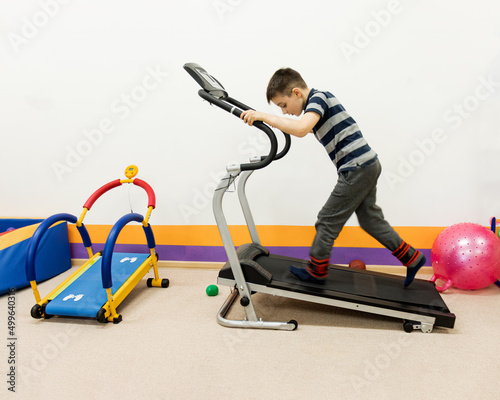 child runs on a treadmill in a children's gym. childrens simulators, sensorics, sensory class,
sensory integration. rehabilitation of sensory disorders,inclusive education, inclusive society.back to s photo