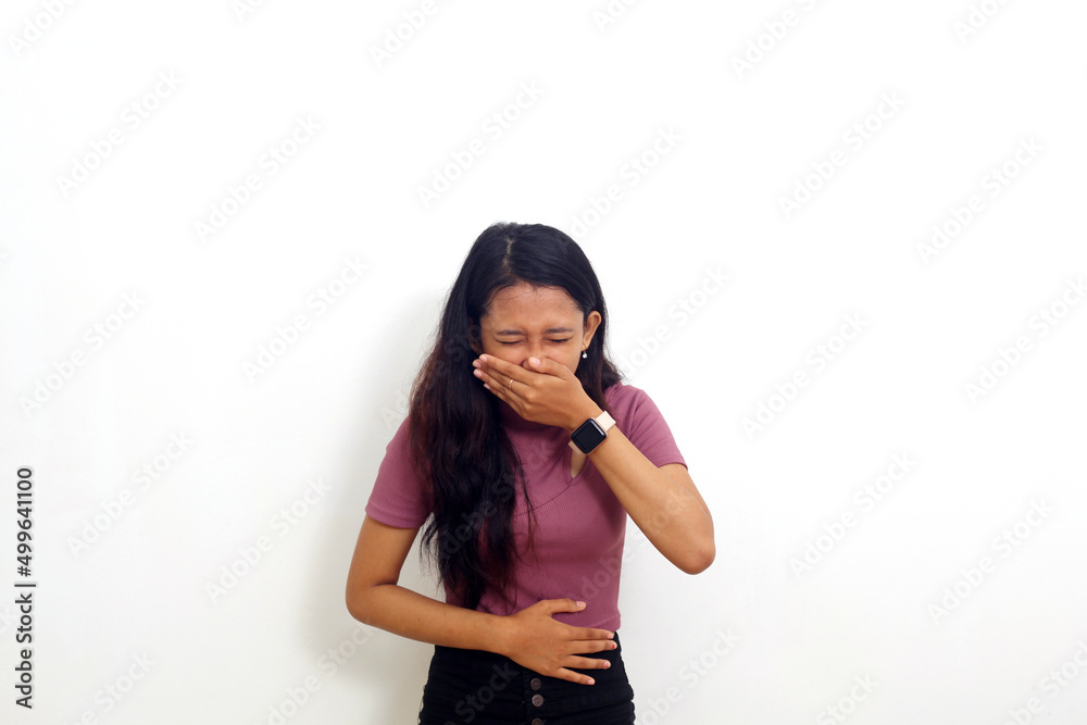 Beautiful asian girl standing holding her stomach and feeling nauseous and going to vomit