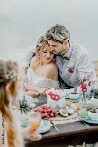The bride and groom celebrate a happy day with friends in nature outside the city.