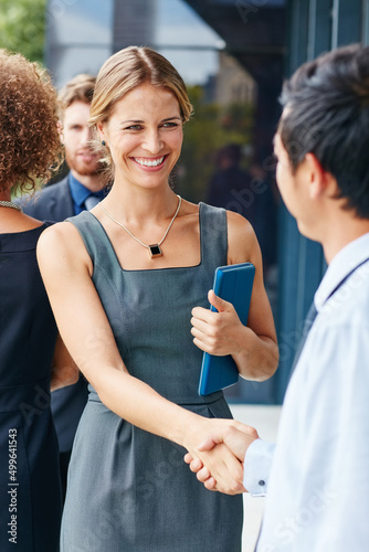 Network your way to success. Shot of a businesswoman and businessman shaking hands outdoors. photo