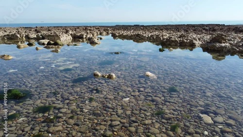 Peacehaven, Sussex - Rocky Beach. 4K Dolly drone footage. Clean, clear rock pools and fossils can be seen. photo