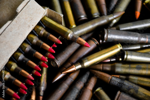 Pile and box of bullets which are new and old on dark background, soft and selective focus.