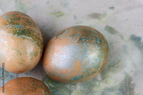 Uova pasquali decorate a spruzzo con macchie turchesi, verde e argento; dettagli della superficie  photo