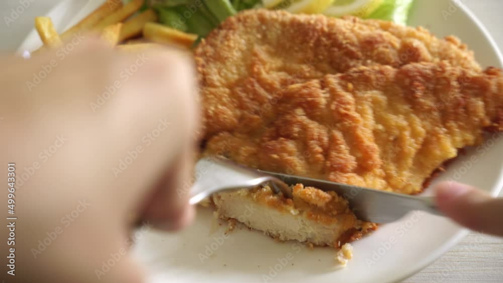 Slicing Breaded Weiner Schnitzel with Potato Chips - Fried Chicken with french fries - European food style Slicing Breaded Weiner Schnitzel with Potato Chips - Fried Chicken with french fries - European food style