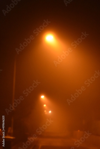 Straße mit Laternen bei Nacht im Nebel