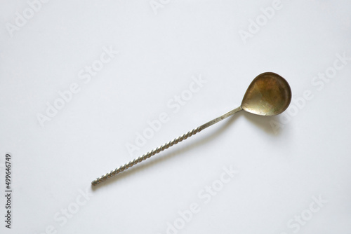 Old homemade teaspoon on a white table close up