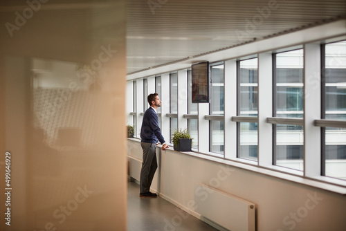 Wallpaper Mural Taking some time to clear his mind and gain his focus. Shot of a young businessman looking through a window in an office. Torontodigital.ca