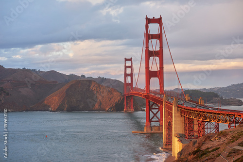 Wide angle view of Golden Gate Bridge against stormy sky at sunset