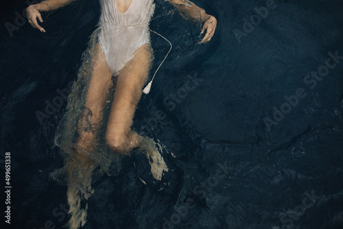 Overhead view of feminine woman swimming in sparkle dress