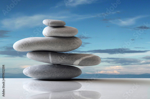 five grey stones balanced over white surface over blue sky Fototapet