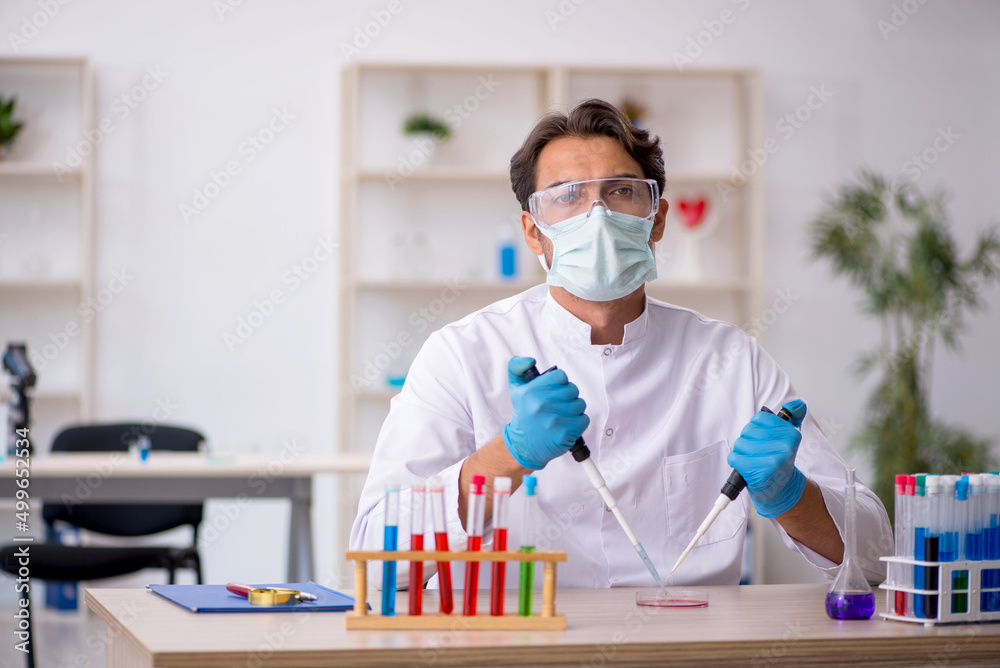 Young male chemist working at the lab Young male chemist working at the lab