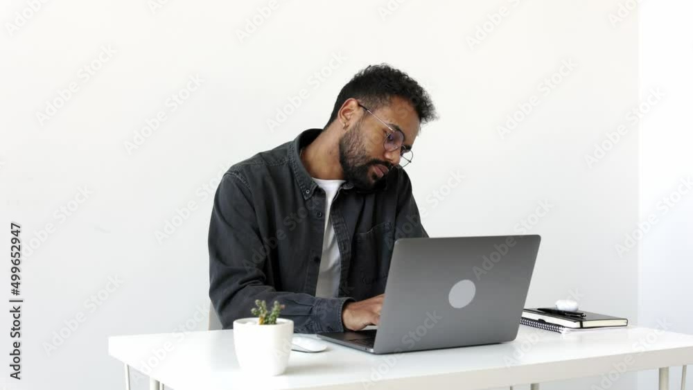 Serious attractive young black male freelance worker hold phone conversation before laptop screen share business success with partner colleague. Happy millennial male remote work or distance education
