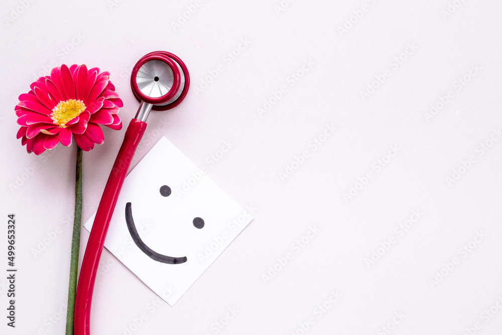 Breast cancer awareness concept with red flower and stethoscope